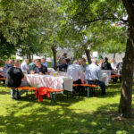 Die Gäste kamen alle zusammen, um ein köstliches Essen im Freien zu sich zu nehmen.